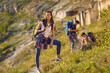 © Studio Romantic - Portrait of a happy and smiling female hiker with a backpack while hiking in the mountains. Girl travels in the summer with friends in the mountains. Concept of active recreation and hiking.