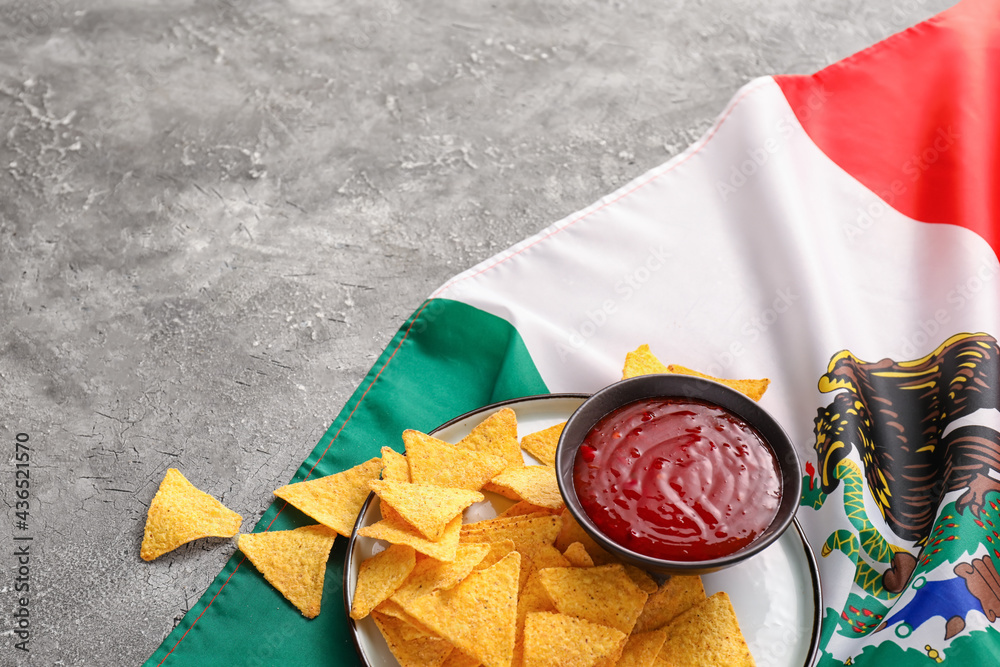 Mexican flag, nachos and sauce on grey background, closeup