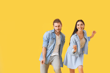 Poster - Happy young couple dancing on color background