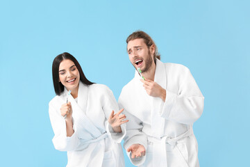 Poster - Young couple with tooth brushes on color background