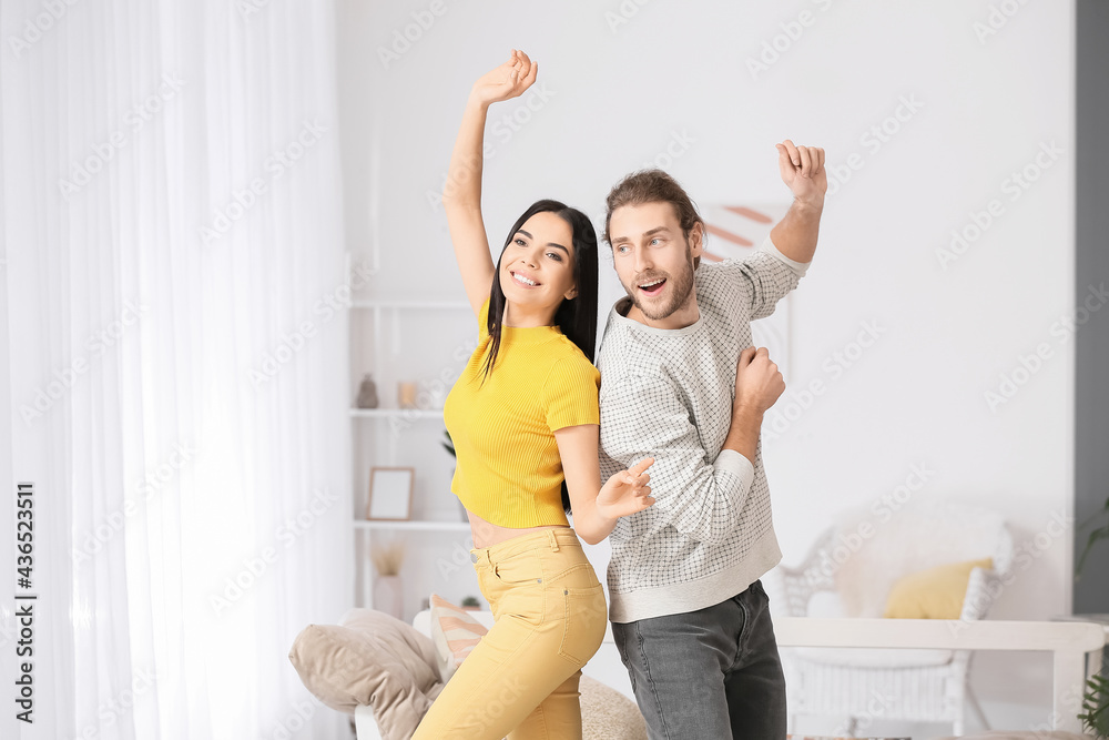 Happy young couple dancing at home