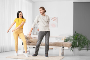 Wall Mural - Happy young couple dancing at home