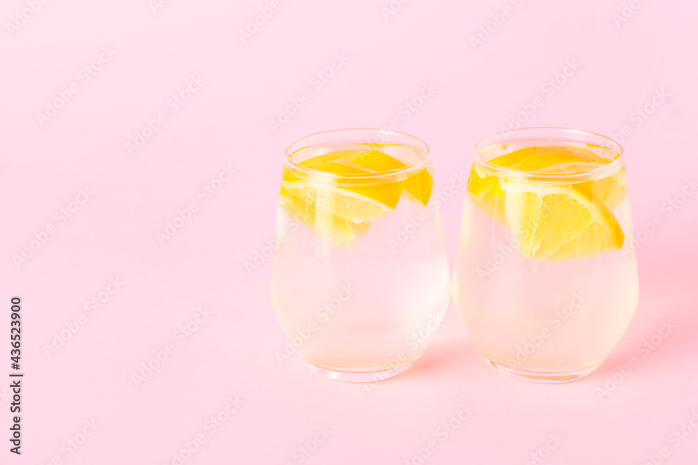 Glasses of tasty cold lemonade on color background