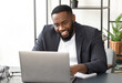 © kucherav - Successful young African American businessman using laptop for video communication with employees. Video conferencing or online education concept