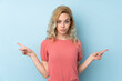 © luismolinero - Young blonde woman isolated on blue background pointing to the laterals having doubts