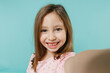 © ViDi Studio - Closeup little fun kid girl 5-6 years old wears pink dress doing selfie shot on mobile phone isolated on pastel blue color background child studio portrait. Mother's Day love family lifestyle concept.