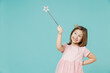 Little fun kid girl princess 5-6 years old wears pink dress crown diadem hold magic wand fairy stick isolated on pastel blue color background child studio. Mother's Day love family lifestyle concept.