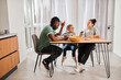 © Yakobchuk Olena - Children having breakfast with appetite and looking into their father