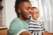 © Yakobchuk Olena - Multiracial man smiling while playing with his two funny daughters at the kitchen