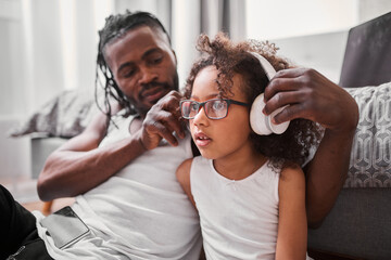 Wall Mural - Father putting headphones on the head of his daughter