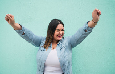 Young plus size woman celebrating victory.