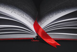 Fototapeta  - Open book with bookmark on dark background, closeup