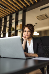 Charming young executive looking at laptop.