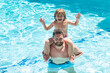 © Volodymyr - Dad carry on shoulders funny child boy in swimming pool. Father and son weekend.