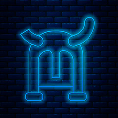 Poster - Glowing neon line Viking in horned helmet icon isolated on brick wall background. Vector