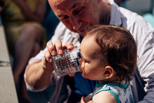 Caring Father Giving Water To His Baby On A Hot Summer Day