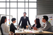 © Stella - Achievement successful young smart businessman sharing his experience success and giving presentation at conference meeting desk, five business people having discussion about project work in office
