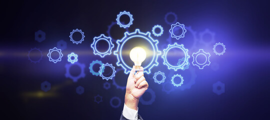 Poster - Creative and business idea concept with glowing light bulb in man hand and digital gears on abstract wallpaper.