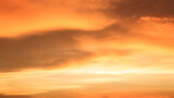 Fototapeta Zachód słońca - Background of orange sky and clouds with sunset light in evening at summer time when with blank copy space, showing about environment, climate concept.