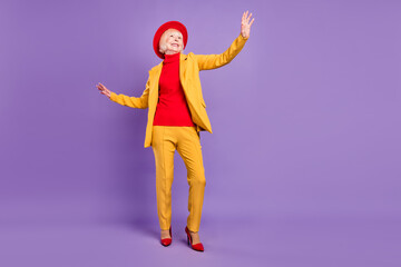 Sticker - Full size photo of optimistic short hairdo elder lady look empty space wear yellow suit cap isolated on purple background