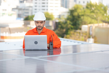 engineer or technician using laptop computer on solar panels on the top of the roof