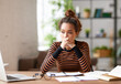 © JenkoAtaman - Stressed young afro american female feeling tired while working remotely or studying online at home