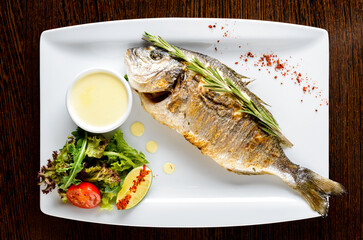 Sticker - fish dorada with fresh salad in restaurant