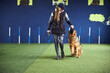 © Svitlana - Focused professional trainer feeding an obedient dog on the leash