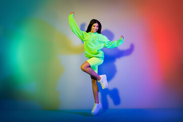 Wall Mural - Full length body size view of attractive cheerful girl jumping having fun isolated over multicolor vivid neon light background