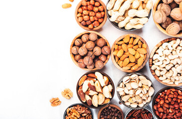 Wall Mural - Nuts in bowls set. Cashews, hazelnuts, walnuts, pistachios etc. Healthy food snack mix on white table, top view
