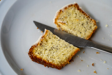 Sticker - Closeup of orange seed poppy cupcake slice halved with a knife a white plate