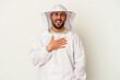 Young apiculture caucasian man isolated on white background laughs out loudly keeping hand on chest.