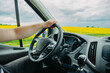 © Mikalai Sayevich - concept of a truck driver, driver's hands on the steering wheel on a sunny day in summer.