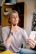 © Maskot - Blond woman consulting with doctor through smart phone at home