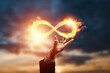 Infinity fire sign over hand of businessman on sunset background