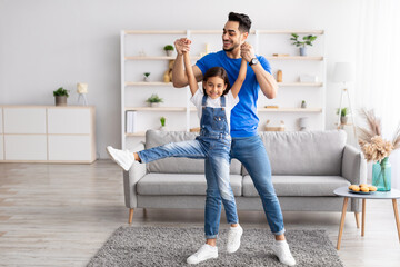 Dad and daughter dancing having fun in living room together