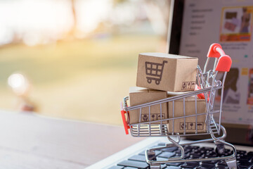 Shopping online. cardboard box with a shopping cart logo in a trolley on laptop keyboard. Shopping service on The online web. offers home delivery