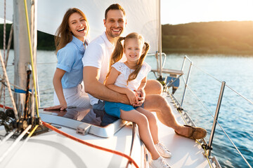 happy family posing sitting on yacht enjoying sea trip outdoors