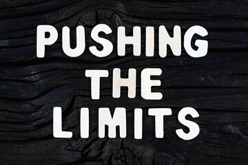 Wall Mural - Pushing The Limits words on dark wooden background. Business, motivational and inspirational concept.