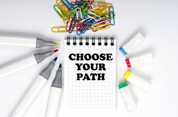 On the table are markers, paper clips and a notebook with the inscription - CHOOSE YOUR PATH