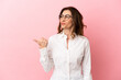 © luismolinero - Middle aged caucasian woman isolated on pink background pointing to the side to present a product
