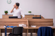 © Elnur - Young businessman employee doing sport exercises at workplace