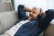 © Prostock-studio - Happy mature man laying on couch, listening to music