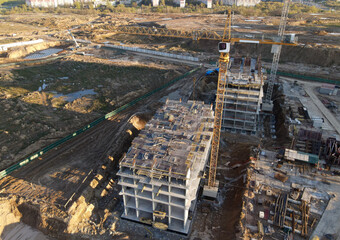 Poster - Tower cranes in action at construction site. Crane during formworks. Soil Compactor leveling ground for construct of foundation for residential building. Construction Foundation in pit. Out of focus