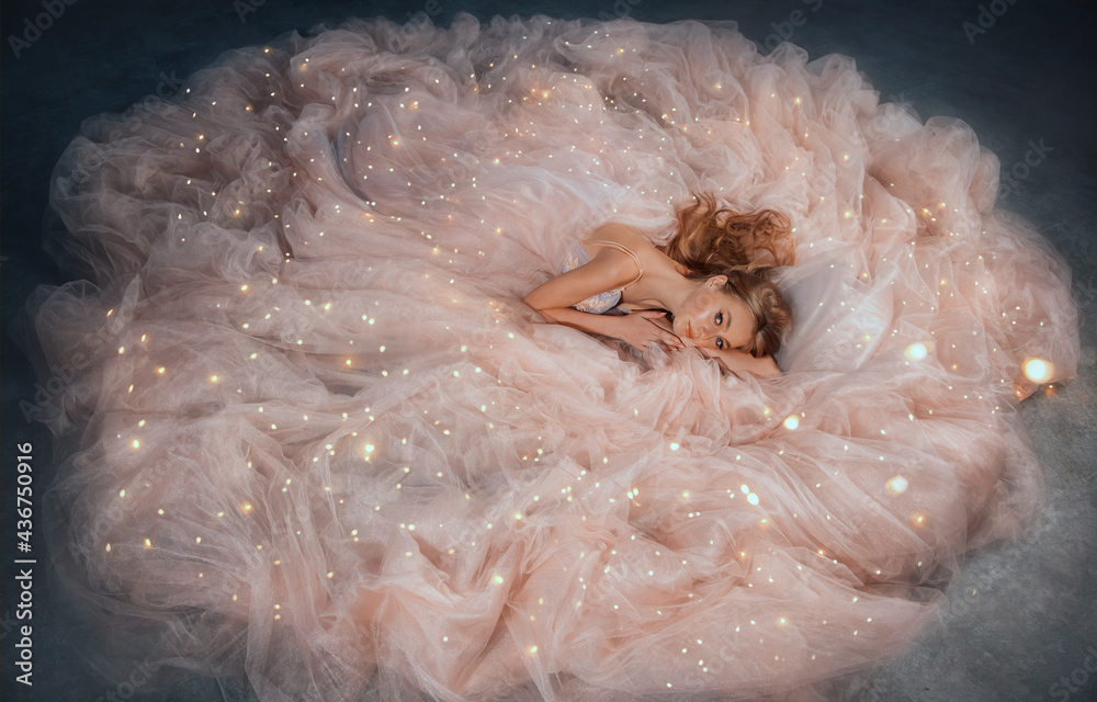 Fairy queen fashion model in luxurious shining pink dress posing in studio.  Princess girl, peach outfit