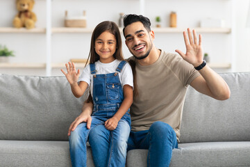 Wall Mural - Happy family waving hands and posing at camera