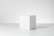 3D render of a simple square block casting a shain a bright white room