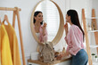 © New Africa - Young woman doing makeup near mirror at home. Morning routine