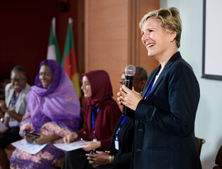 A Western Business Woman Speaking into a Microphone