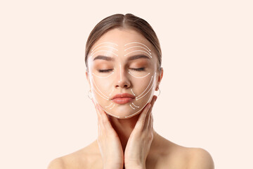 Wall Mural - Young woman with arrows for massaging on her face against light background